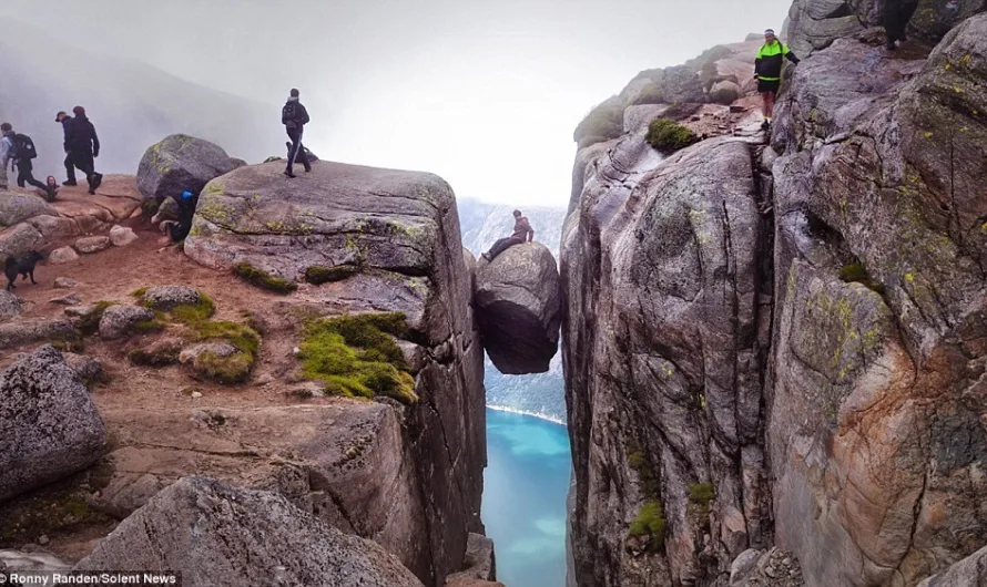 Are these the most dangerous holiday snaps ever taken? Tourists brave 800-FOOT drop to stand on boulder wedged between cliffs